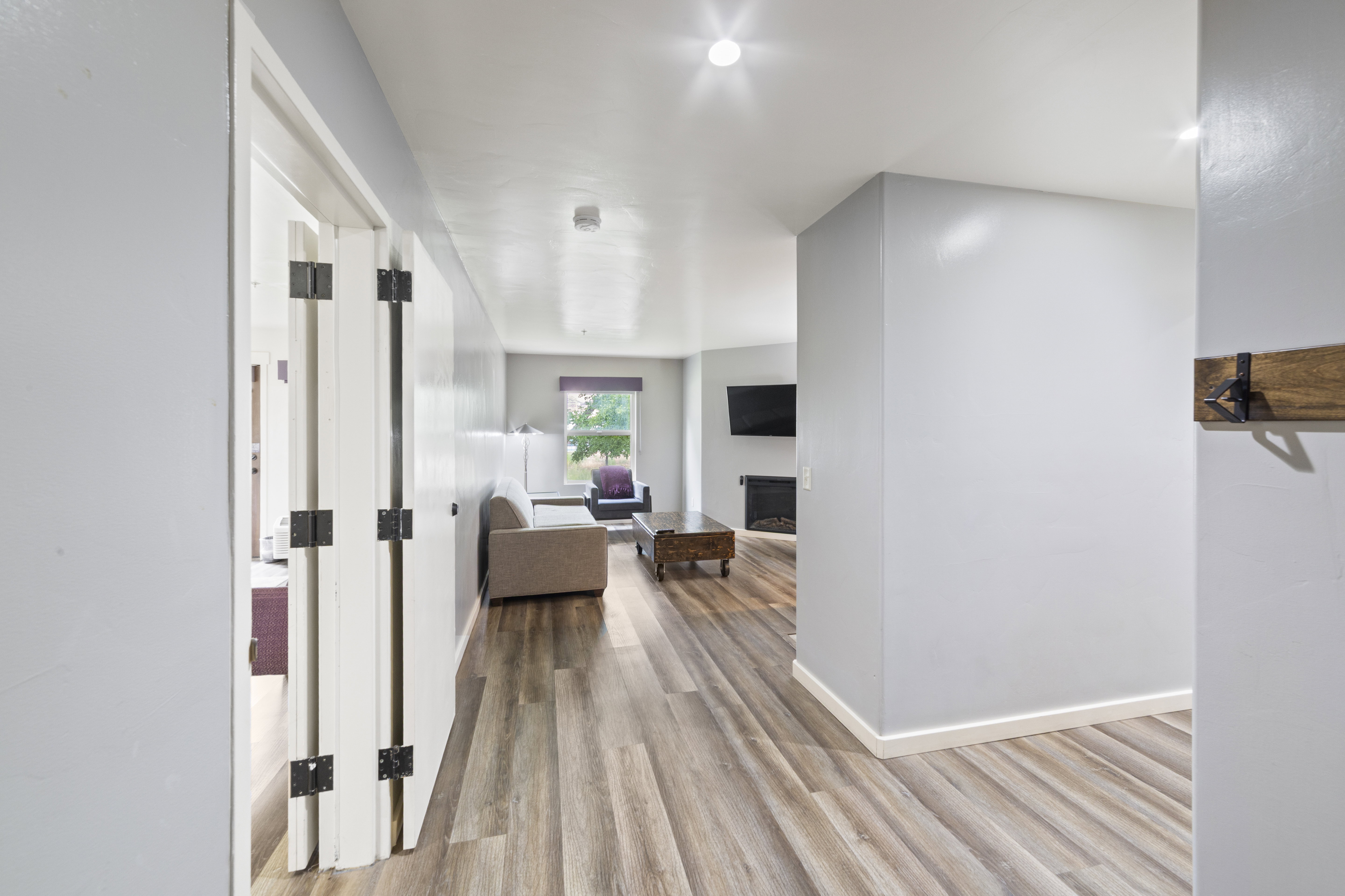 Corridor featuring light wood-type flooring and baseboards