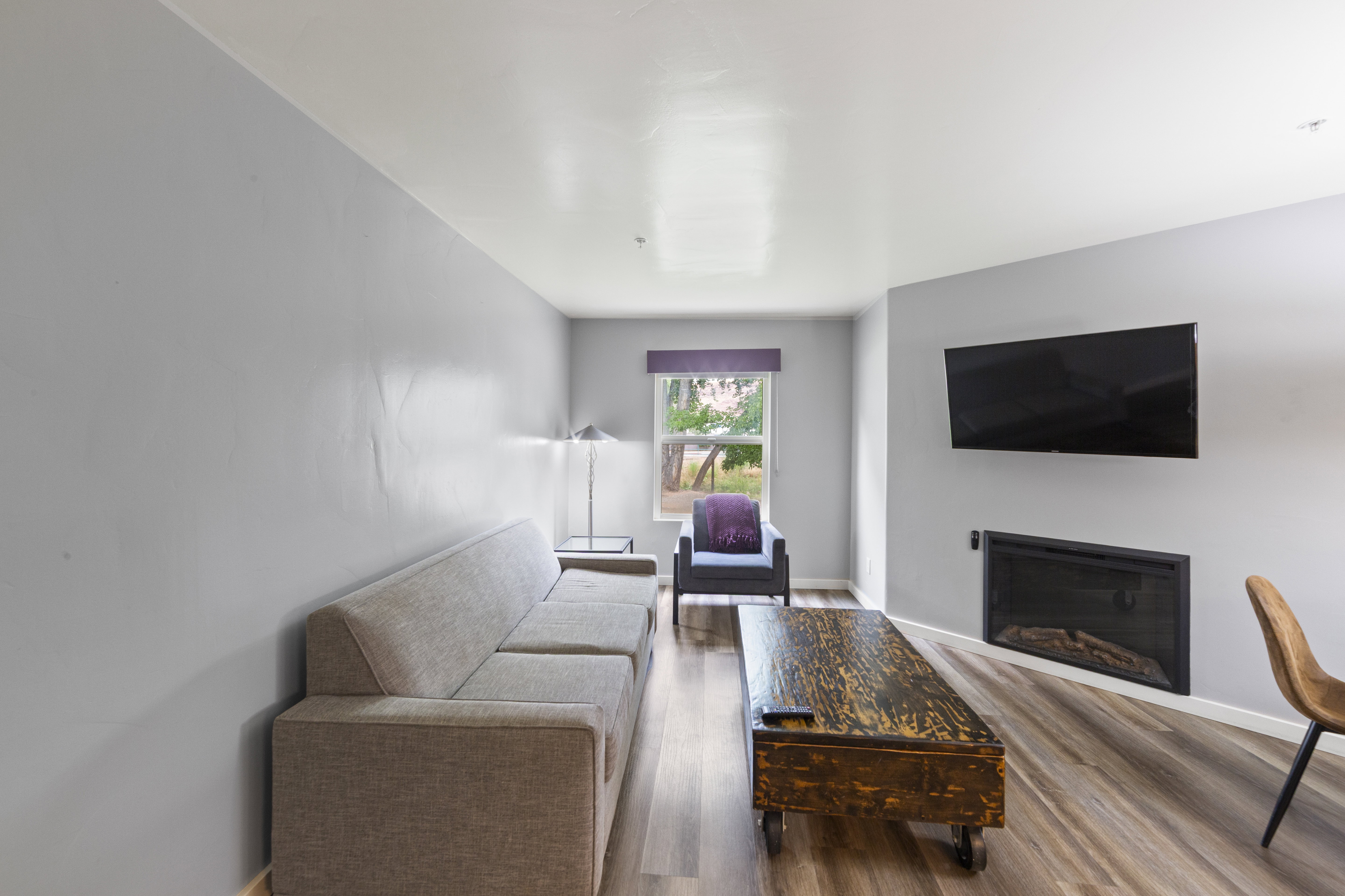 Living room featuring a glass covered fireplace and wood finished floors
