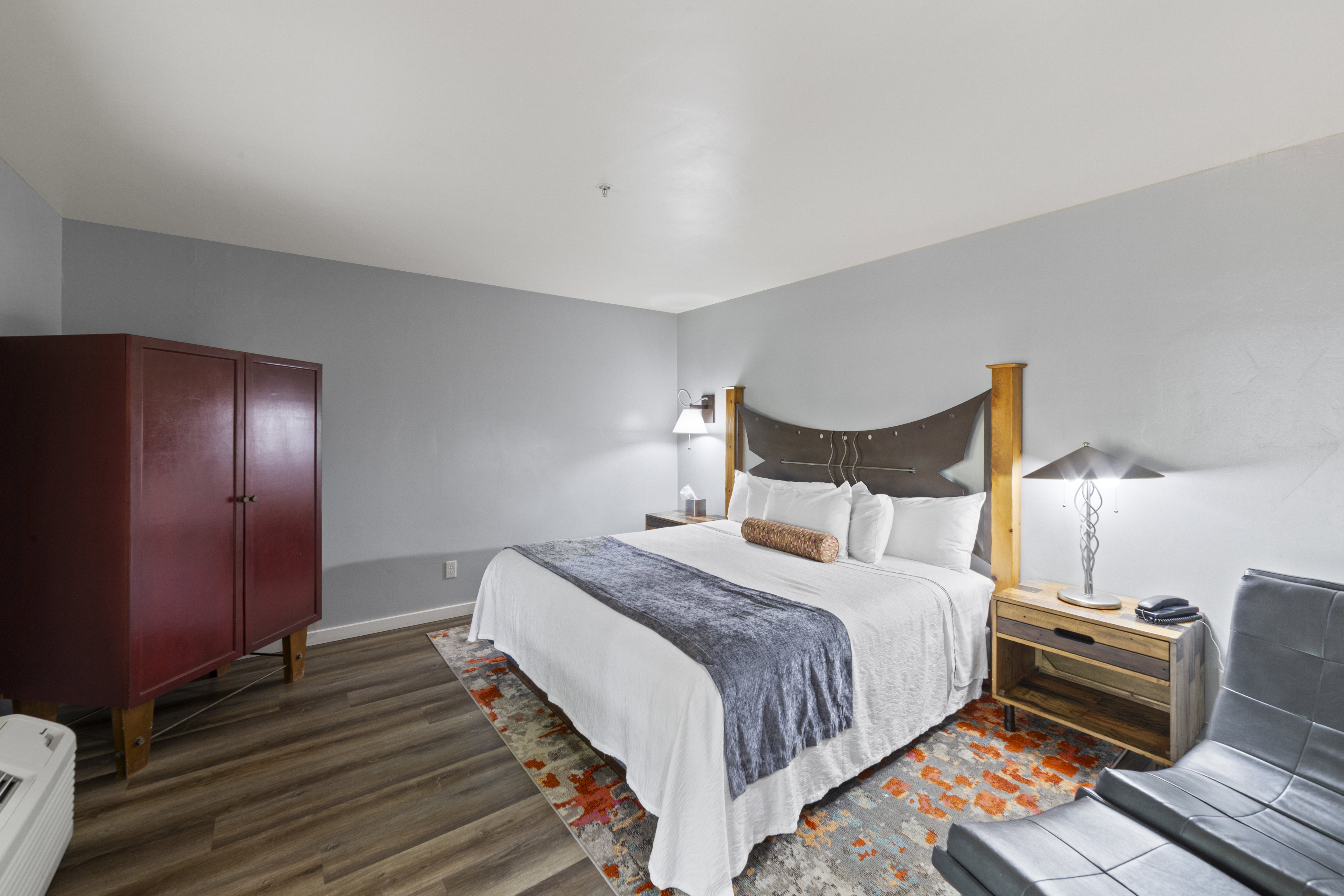 Bedroom with dark wood finished floors and baseboards
