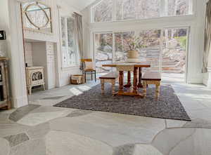 Dining area featuring stone floors, lofted ceiling, and wood walls
