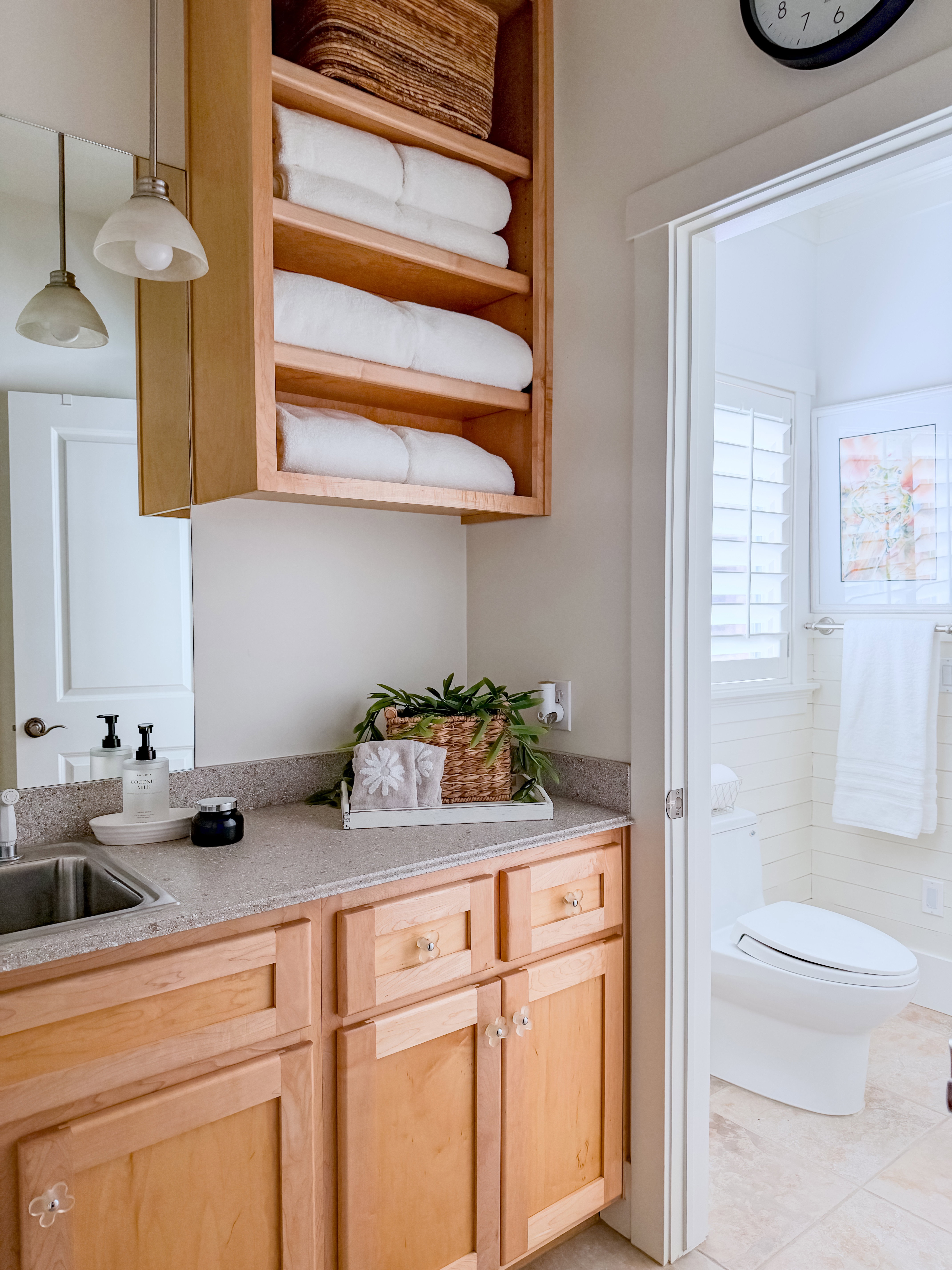 Kitchen with light wood finish cabinets, pendant lighting, open shelves, light tile patterned flooring, and light stone countertops