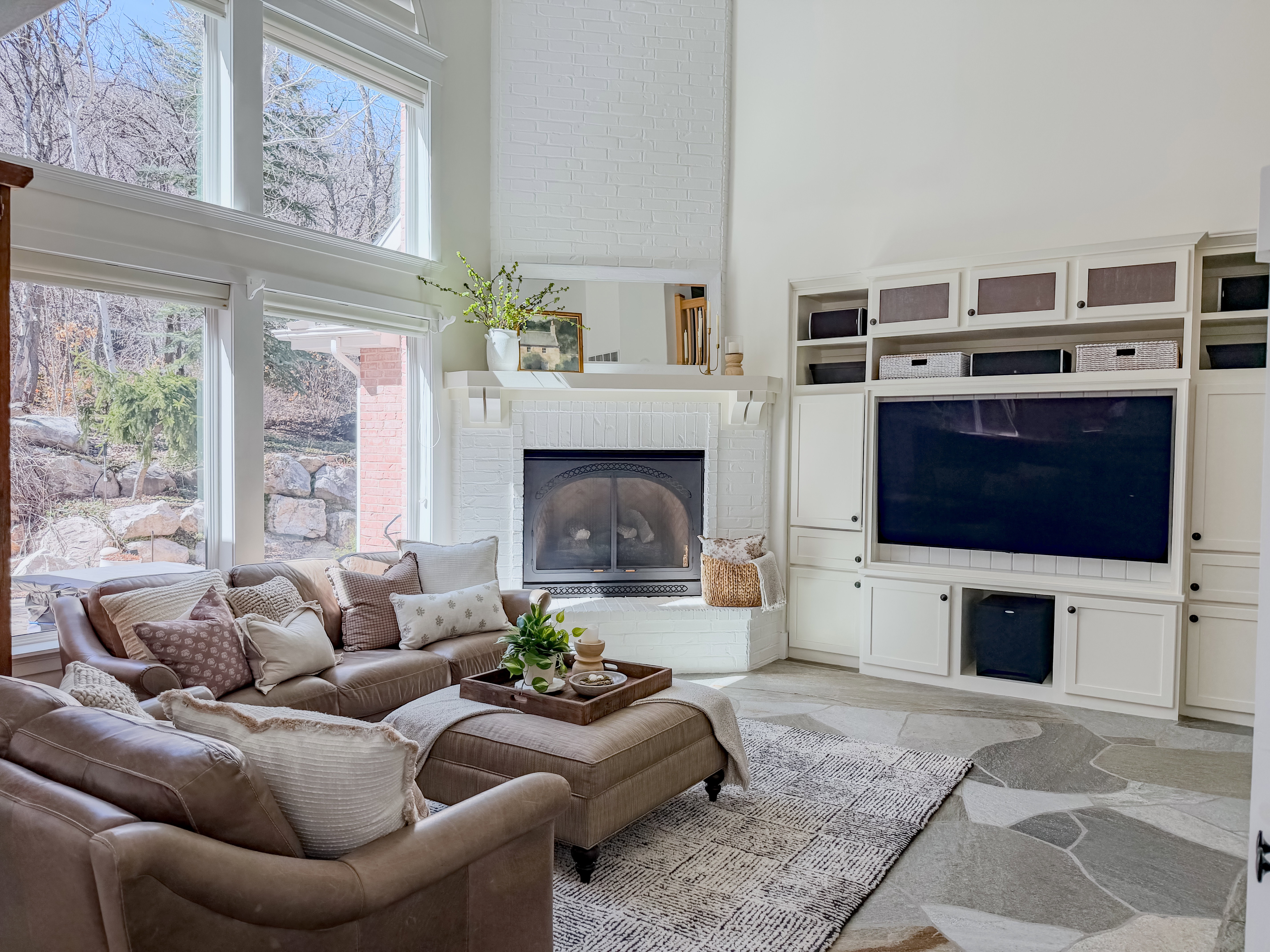 Living area with a high ceiling, light stone finish flooring, and a fireplace