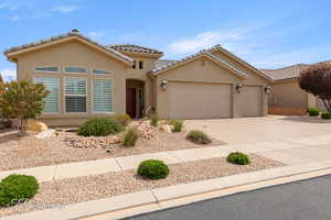 Mediterranean / spanish-style home with driveway, a garage, stucco siding, and a tiled roof