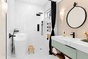 Bathroom with tile walls, vanity, walk in shower, and a freestanding bath