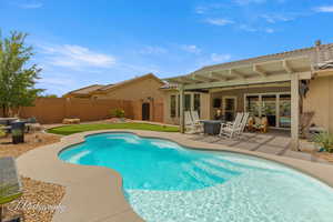 View of swimming pool with patio surround, an outdoor fire pit, a fenced backyard, and a pergola