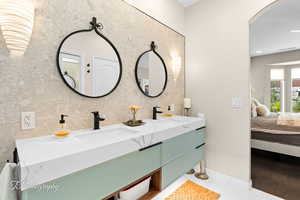 Ensuite bathroom with double vanity and baseboards