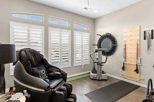 Exercise area featuring baseboards and wood finished floors