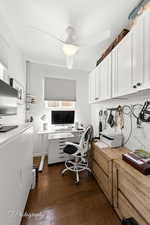 Office space with dark wood-style floors and ceiling fan