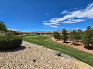 View of community with view of golf course and a water and mountain view