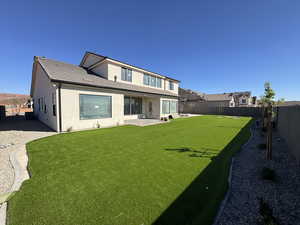 Rear view of house with stucco siding, a patio area, and a fenced backyard