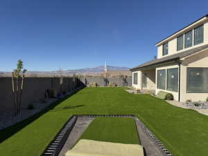 Fenced backyard featuring a mountain view and a patio area