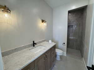 Bathroom featuring vanity, light tile patterned floors, and tiled shower
