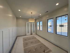 Unfurnished dining area with a decorative wall, wainscoting, and recessed lighting