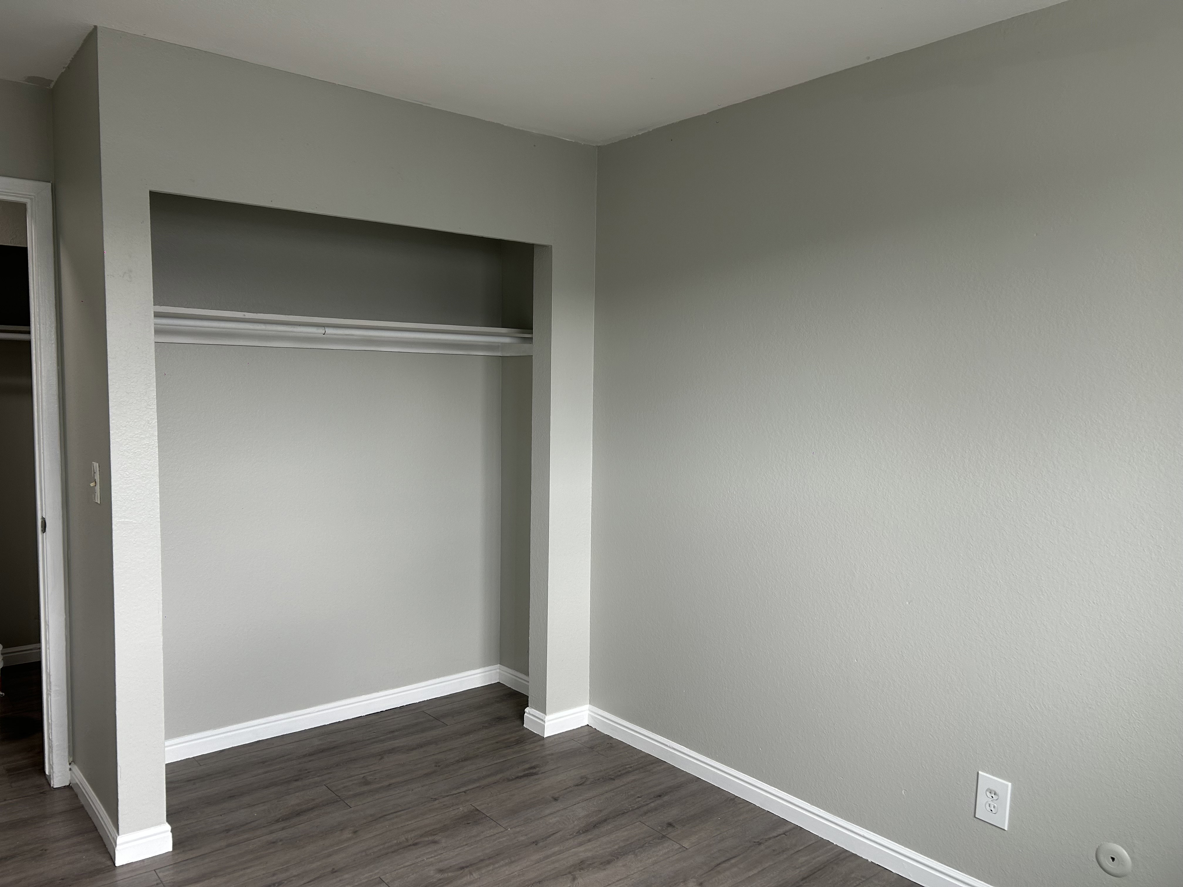Unfurnished bedroom featuring dark wood-style flooring and a closet