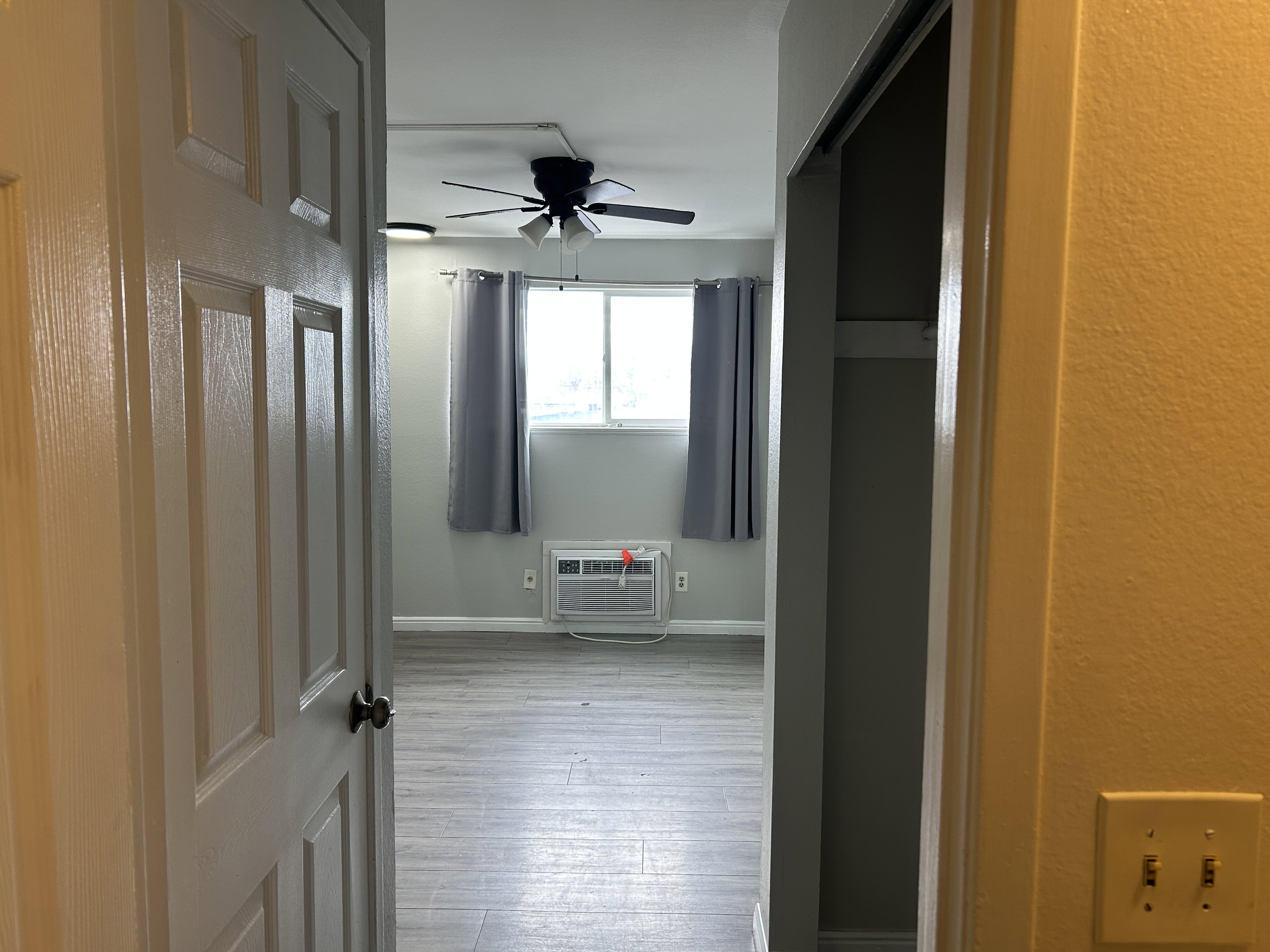 Hallway with light wood finished floors and a textured wall