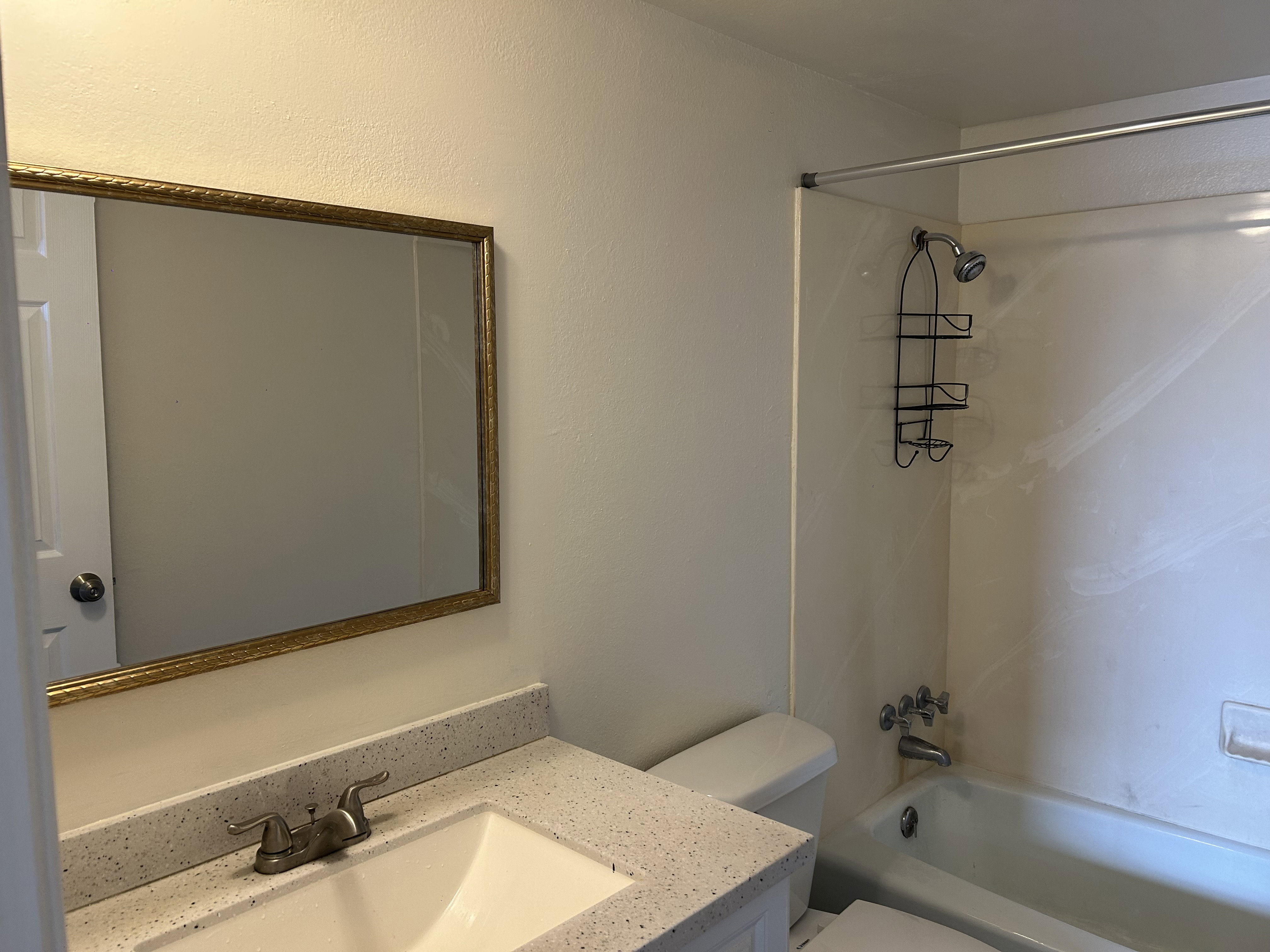 Bathroom featuring vanity, bathtub / shower combination, and a textured wall