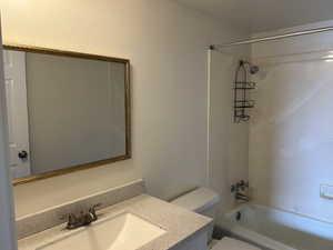 Bathroom featuring vanity, bathtub / shower combination, and a textured wall