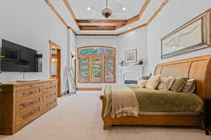 Bedroom featuring ornamental molding, light colored carpet, a tray ceiling, ceiling fan, and recessed lighting