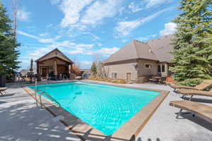 View of swimming pool with patio surround and outdoor dining space