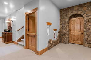 Hallway featuring light colored carpet and baseboards