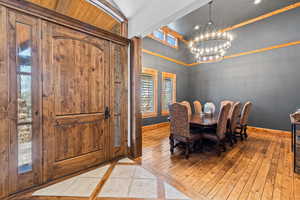 Dining space featuring suspended lighting, light wood-style floors, and inlaid floor details