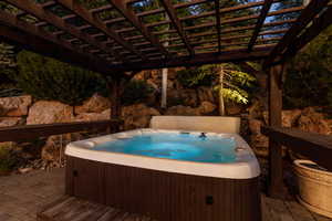Deck featuring a patio, a pergola, and a hot tub