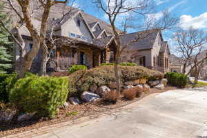 View of front of house with stone siding and stucco siding