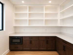 Built-in shelving and dark wood-finish cabinetry with matte black hardware