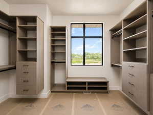 Custom primary closet system featuring varied shelving, integrated drawers, and hanging rods, area for stackable W/D