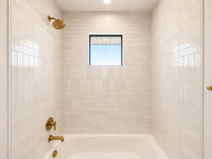 Tub and shower combination featuring floor-to-ceiling cream subway tile with contrasting horizontal and vertical patterns.