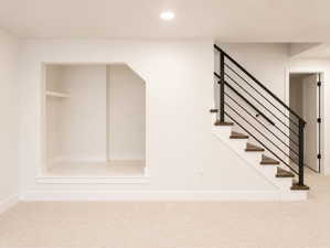 Book nook area under basement staircase. Open railing at base of stairs.
