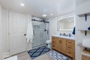 NEW Full bathroom with vanity, a marble finish shower, light wood-type flooring, and a textured ceiling