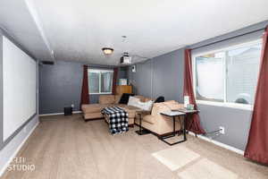 Living area featuring light colored carpet and baseboards
