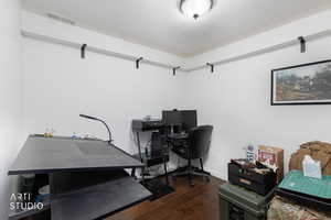Home office featuring dark wood-style flooring and baseboards