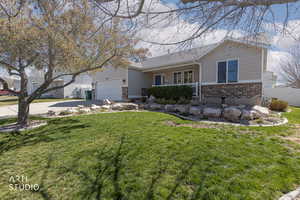View of front of house with brick siding, covered porch, driveway, a gate, and roof with shingles