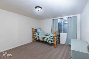 Carpeted bedroom featuring baseboards