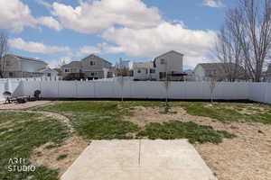Fenced backyard featuring a residential view and an outdoor fire pit