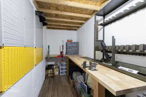 Basement featuring dark wood-style floors and a workshop area