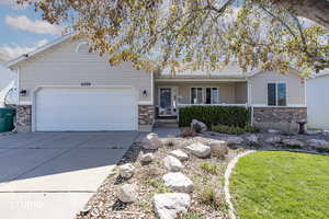 Single story home featuring a porch, brick siding, concrete driveway, and an attached garage