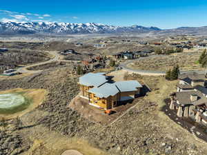 Aerial view of property's location featuring nearby golf view and a mountain backdrop