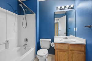 Full bathroom with vanity, bathing tub / shower combination, light tile patterned flooring, and a textured wall