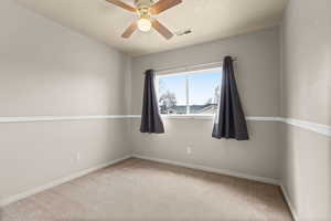 Empty room featuring light carpet and a ceiling fan