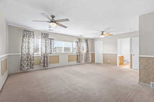Unfurnished room featuring light carpet and a ceiling fan