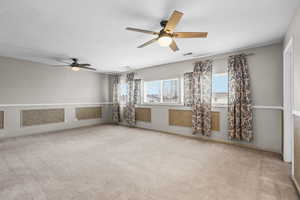 Unfurnished room featuring ceiling fan and light carpet