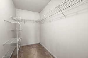 Walk in closet with dark carpet