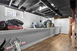 Basement featuring wood finished floors and washer / dryer