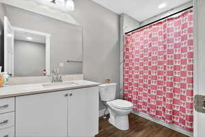 Full bathroom featuring vanity, dark wood finished floors, recessed lighting, and shower / tub combo with curtain