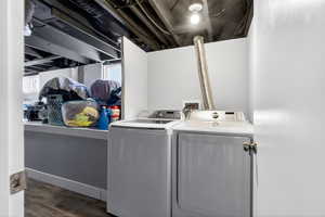 Laundry area with washer and clothes dryer and dark wood-style flooring