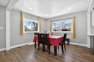 Dining space with dark wood-style floors and recessed lighting