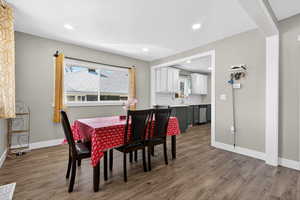 Dining room with dark wood-style flooring and recessed lighting
